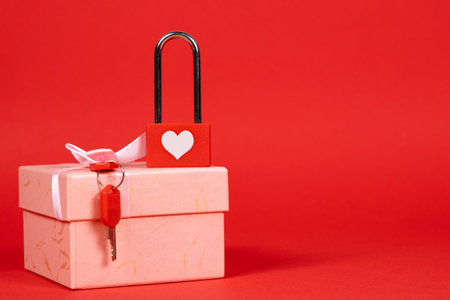 Valentines Day Card - lock with keys on a gift box on a red background, a place for text