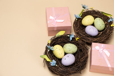 Gifts for Easter, Easter sale. Eggs in nests and gift boxes on a beige background.の写真素材