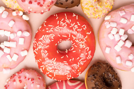 Donuts with red and pink glaze, top view. Lots of donuts, sweet and delicious food.の写真素材