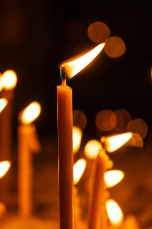 A lot of burning candles in the temple in the dark. The concept of religion, prayer and God