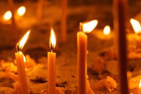 Burning candles in the church on a dark background. The idea of prayer and religion.