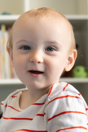 Portrait of a one-year-old baby, a blonde boy in a childrens room.