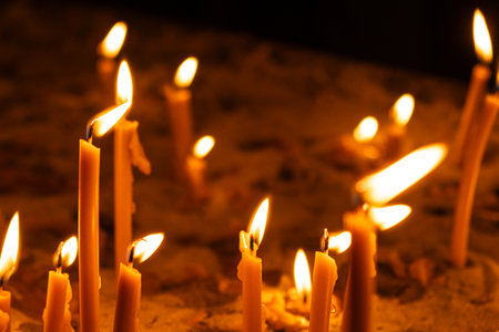 A lot of burning candles in the temple in the dark. The concept of religion, prayer and God.の写真素材