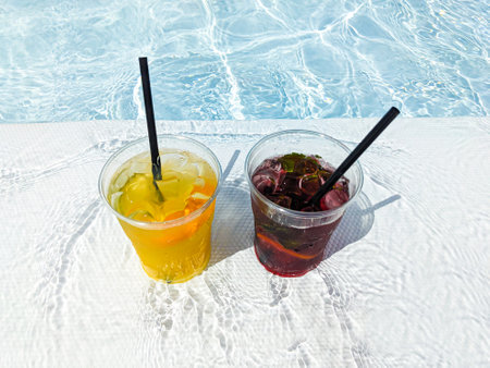 Two summer orange and berry lemonades by the pool.