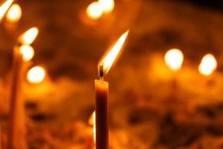 A lot of burning candles in the temple in the dark. The concept of religion, prayer and Godの写真素材
