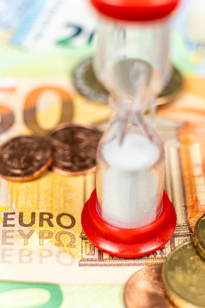 Time is money. Hourglass on euro banknotes close-upの写真素材