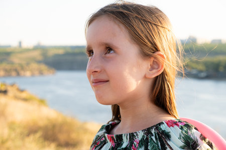 Portrait of a little girl walking in nature looking to the side, a place for text.の写真素材