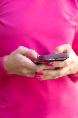 Woman uses smartphone, mobile phone, outdoors, close-up handsの写真素材