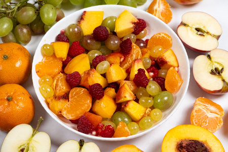 Fruit salad with sliced fruit, mixed grapes, raspberries, nectarines, tangerines and apples.の写真素材