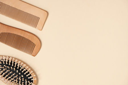 Wooden combs and hair care brush on beige background, top view, space for text.の写真素材