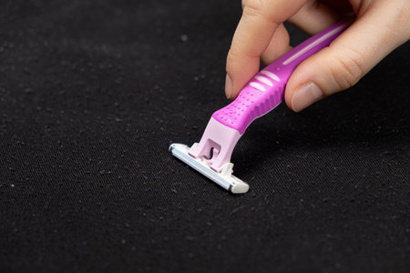 Razor on sweater. Removing pills from clothingの写真素材