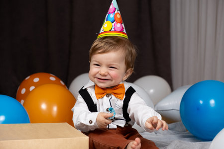 A toddler celebrates his first birthday among balloonsの写真素材