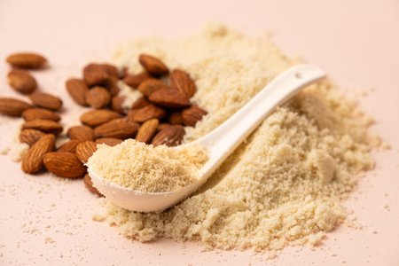Almond flour and almonds on a beige background.の写真素材