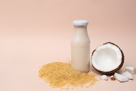 Rice coconut vegan milk in glass bottles on beige background, copy space for textの写真素材