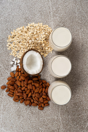 Types of plant-based milk in glasses. Oat, coconut and almond milk.