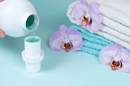 The process of pouring natural eco gel liquid laundry detergent from the bottle into the cap