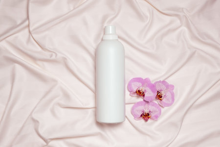 Floral scented laundry detergent on satin fabric top view, copy space for textの写真素材