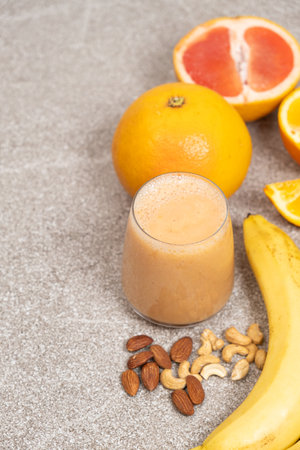 Fruit nut smoothie in a glass on a stone backgroundの写真素材