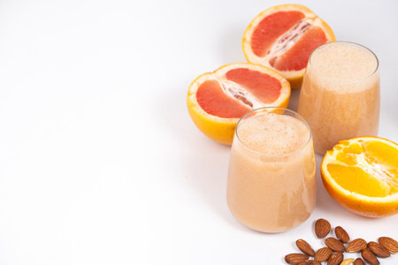 Fruit smoothie in a glass, grapefruit and orange on white background, copy space for text.の写真素材