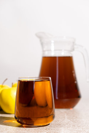 Apple juice in a glass and jug on a white background.の写真素材