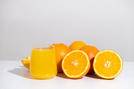 Orange juice in a glass and half a fresh orange, space for text.の写真素材