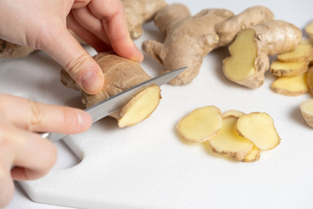 The process of cutting ginger root with a knifeの写真素材