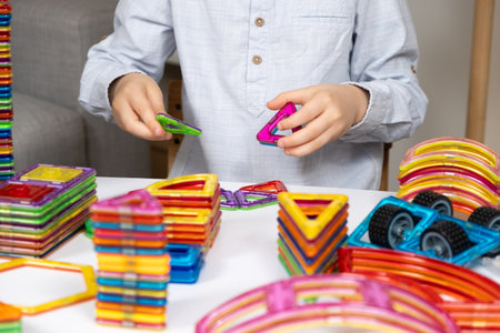 Child playing with magnetic constructor, hands close-up.の写真素材