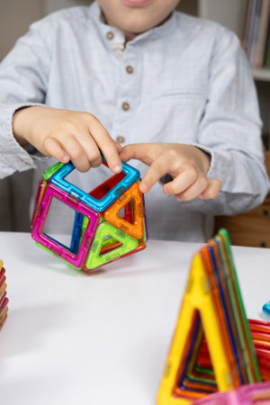 Child playing with magnetic constructor, hands close-up.の写真素材