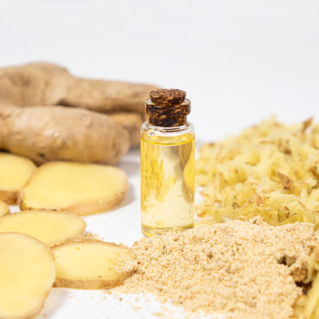 Natural ginger oil in glass bottle among ginger roots.