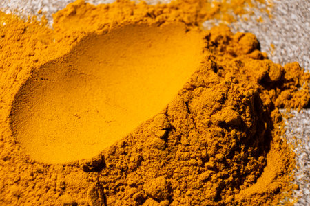 A smear of turmeric on a gray background, top view.