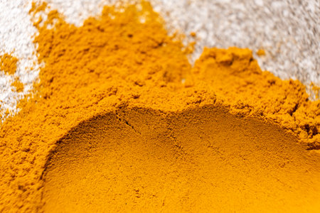 A smear of turmeric on a gray background, top view.
