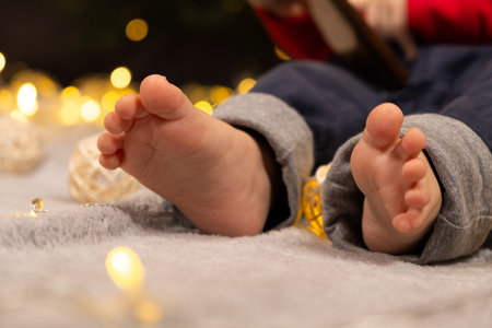 Bare feet of a little baby. Cozy Christmas mood.の写真素材