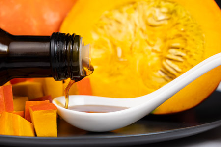 Organic pumpkin seed oil pours out of the bottle.の写真素材