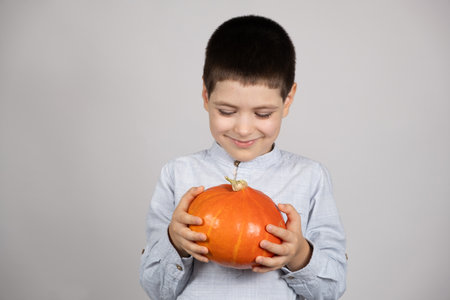 Cute happy child with small Hokkaido pumpkin on white background.の写真素材