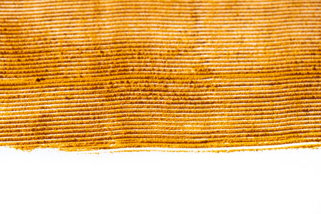 Abstract orange background of spilled turmeric powder on white background top view.