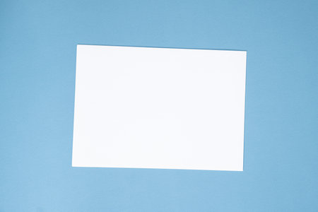 Blank Sheet of Paper on Blue Background, Top View, Space for Text.の写真素材