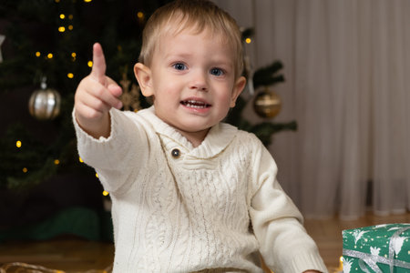 Cute little toddler showing index finger up at Christmas pointing at something.