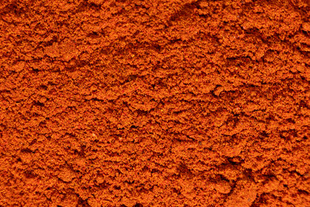 Ground paprika, red terracotta spice background, art in cooking.