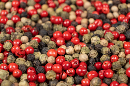 A mixture of different peppercorns white, black, red and green peppers spices