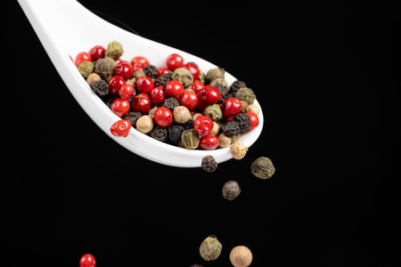 Different types of peppercorns pouring. Red, green, white and black pepperの写真素材