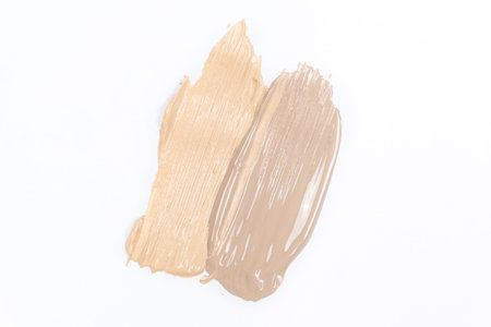 Two strokes of different shades of foundation on a white background