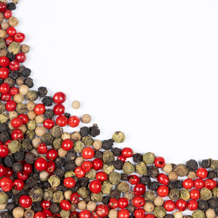 Red, green, white and black peppercorns on a white backgroundの写真素材