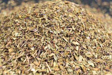 Pile of chopped dry basil seasoning on a black backgroundの写真素材