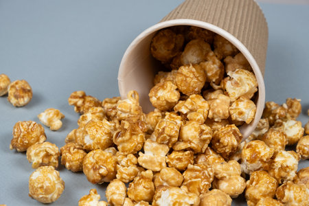 Sweet caramelized popcorn spilled out of the glassの写真素材