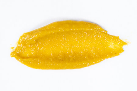 Smear of mustard sauce on white background isolate, creativity in cooking, macro texture.