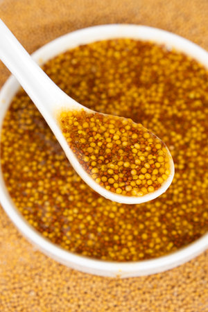 Traditional French Dijon mustard in a spoon on a white background.の写真素材