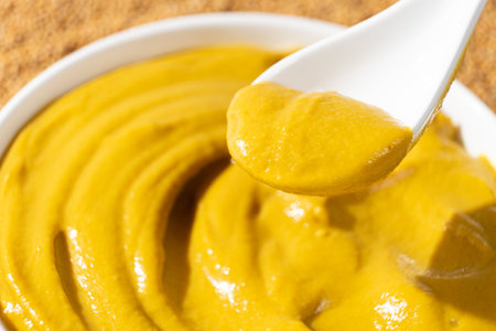 Traditional spicy mustard sauce in a spoon close-upの写真素材