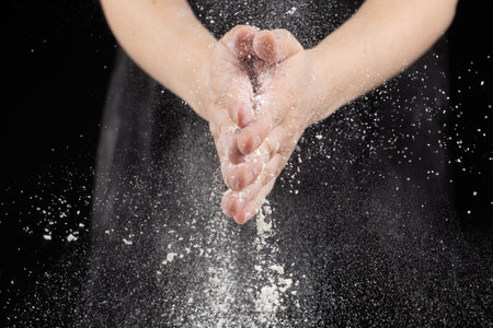 Splash of wheat flour, cook working with dough, hands close-upの写真素材