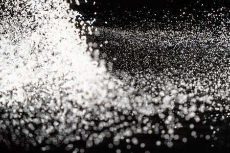 Abstract black and white background of pouring flour, space for text