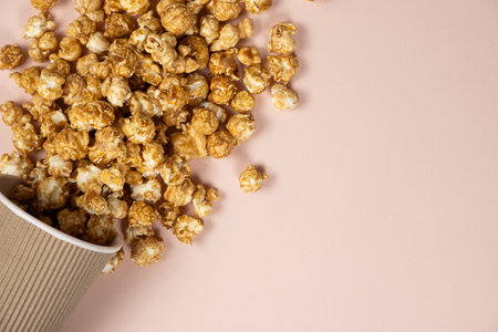 Sweet caramelized popcorn spilled out of the glass. Copy space for textの写真素材